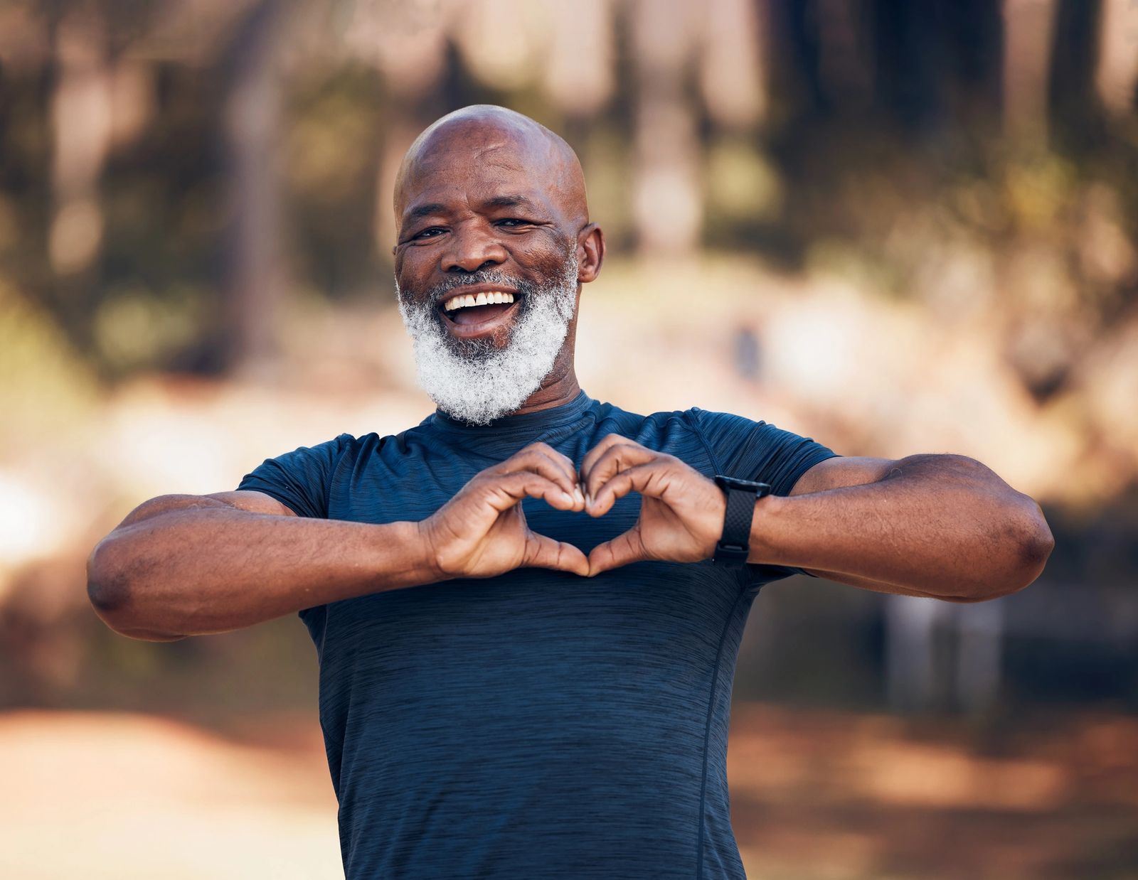 A senior making a heart shape with his hands