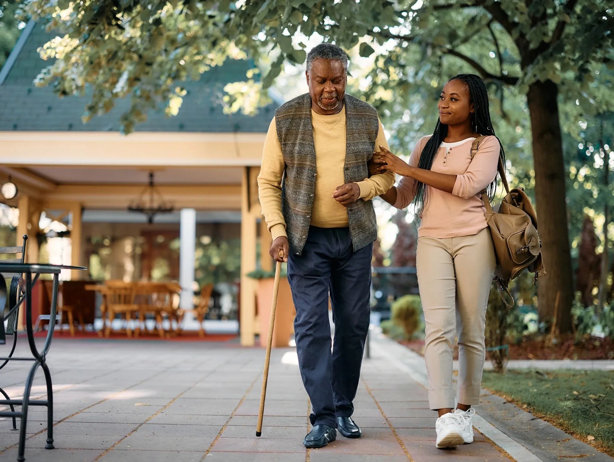 A caregiver walking with a senior to the center